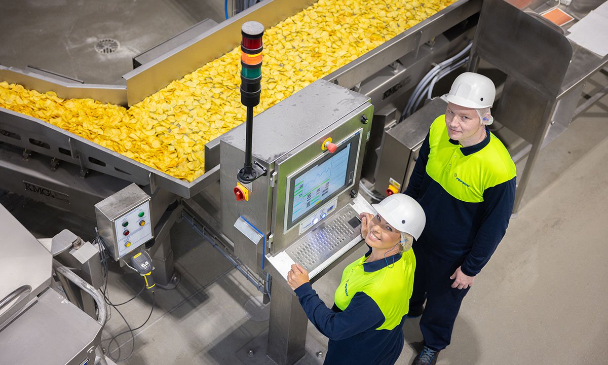 Two associates monitoring equipment in a manufacturing plant