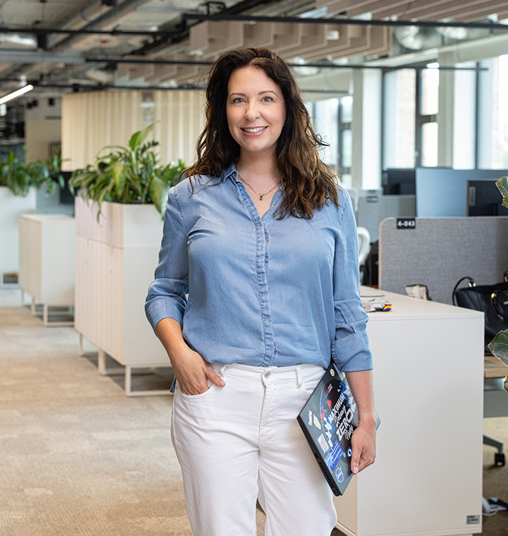 Female associate standing near office computer stations