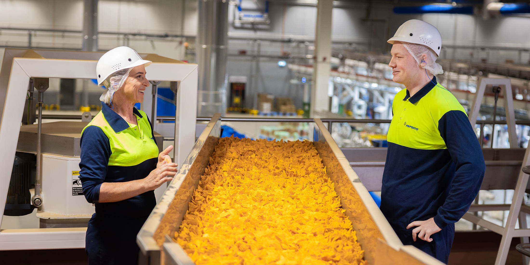 Associates working near a chip conveyor belt