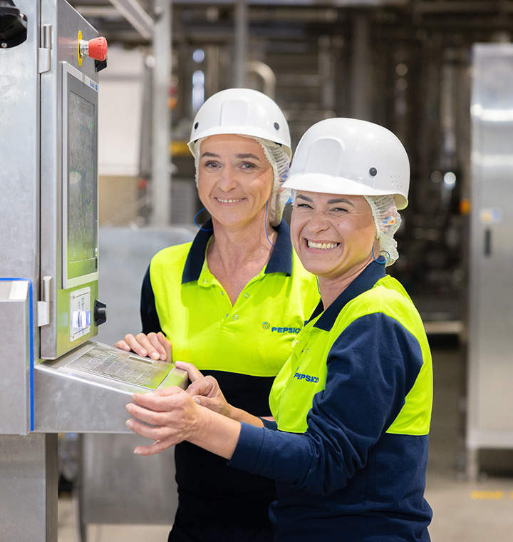 Associates working together on plant machinery