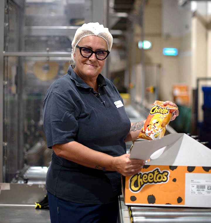 Associate packing Cheetos bags into a box